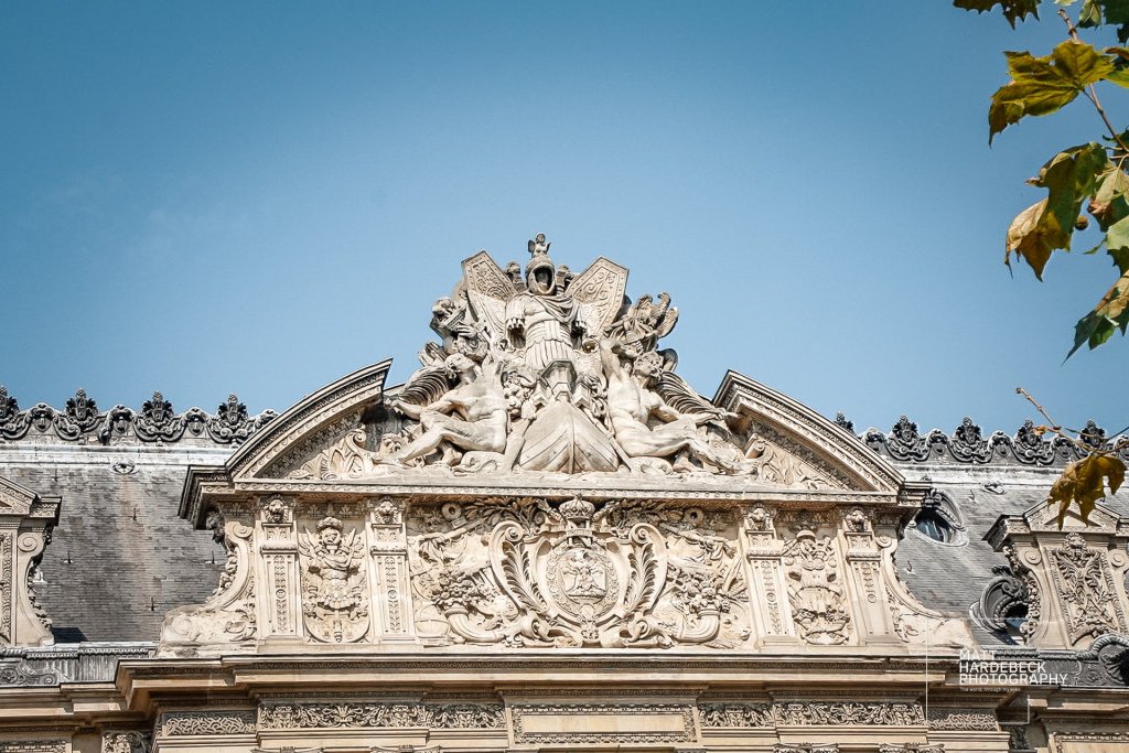 Stone carvings and French Baroque detailing on the Louvre’s pediment.