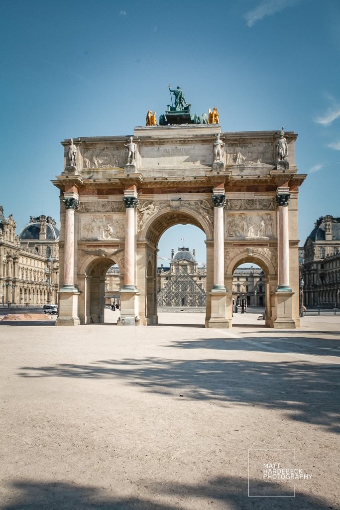 The Arc de Triomphe du Carrousel with the Louvre pyramid in the background.