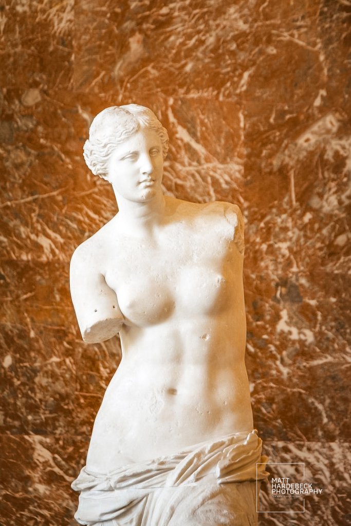 Timeless and elegant, the Venus de Milo holds court in her marble sanctuary—graceful even without arms.