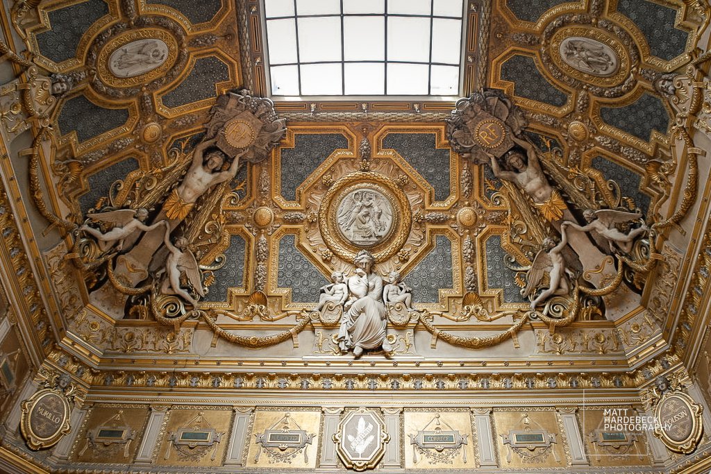 Above the art, there’s more art—ornate frieze work crowns the gallery walls with timeless grace.