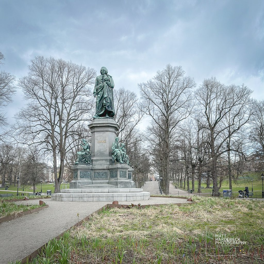 Statue of Carl Linnaeus in Humlegården, still framed by leafless branches in early spring.
