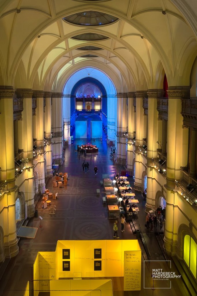 Interior of the Nordiska Museet with vaulted ceilings and warm lighting.