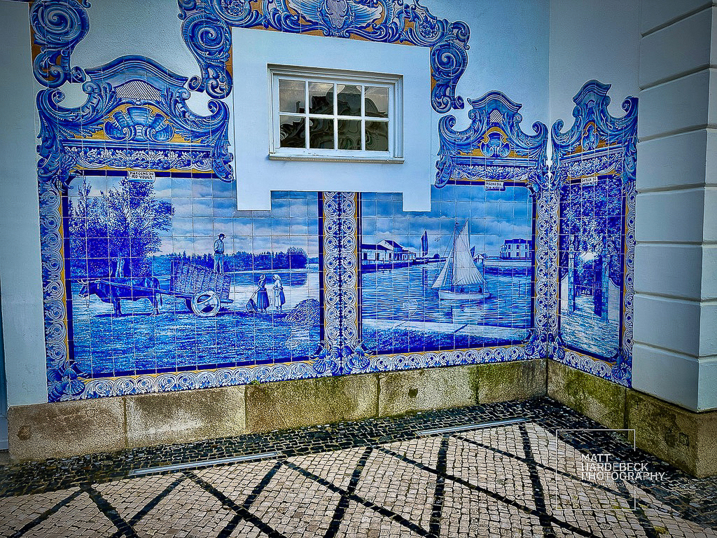 Detailed blue-and-white azulejo mural depicting rural and maritime scenes in Aveiro, Portugal.