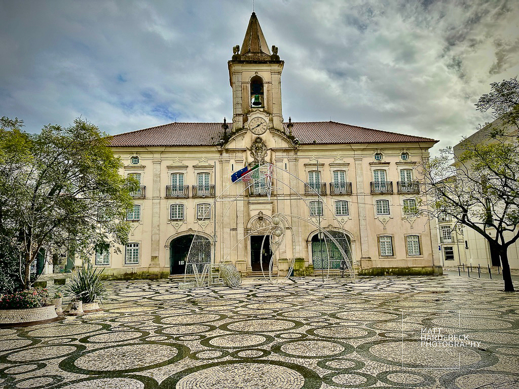 Baroque-style municipal building in Aveiro, Portugal, with an ornate clock tower and patterned square.