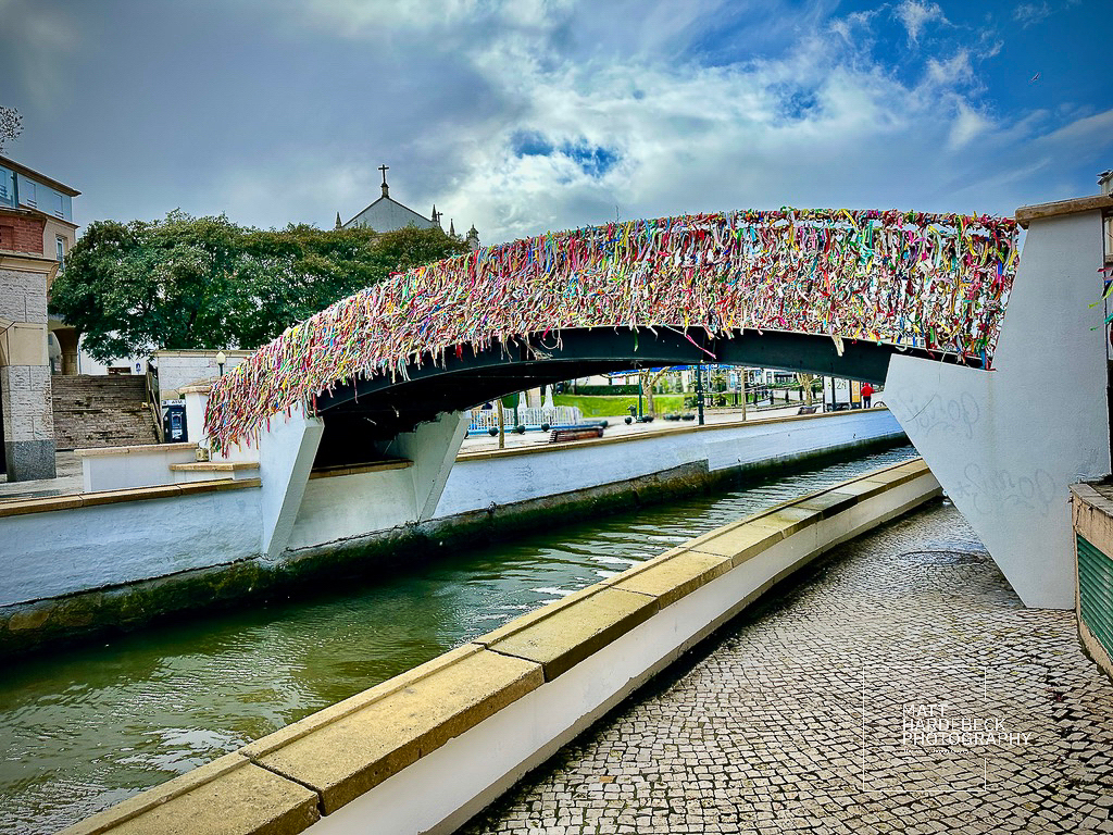 Pedestrian bridge in Aveiro, Portugal, covered in colorful ribbons.