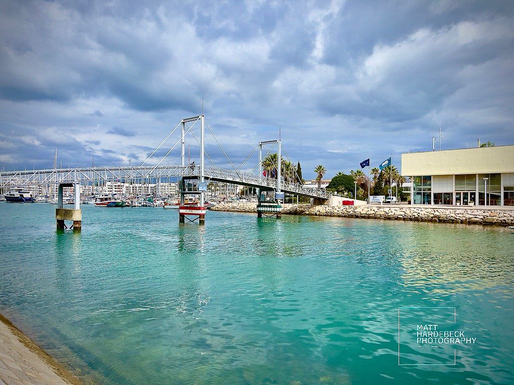 Lagos Marina drawbridge spanning turquoise waters, with boats docked nearby.