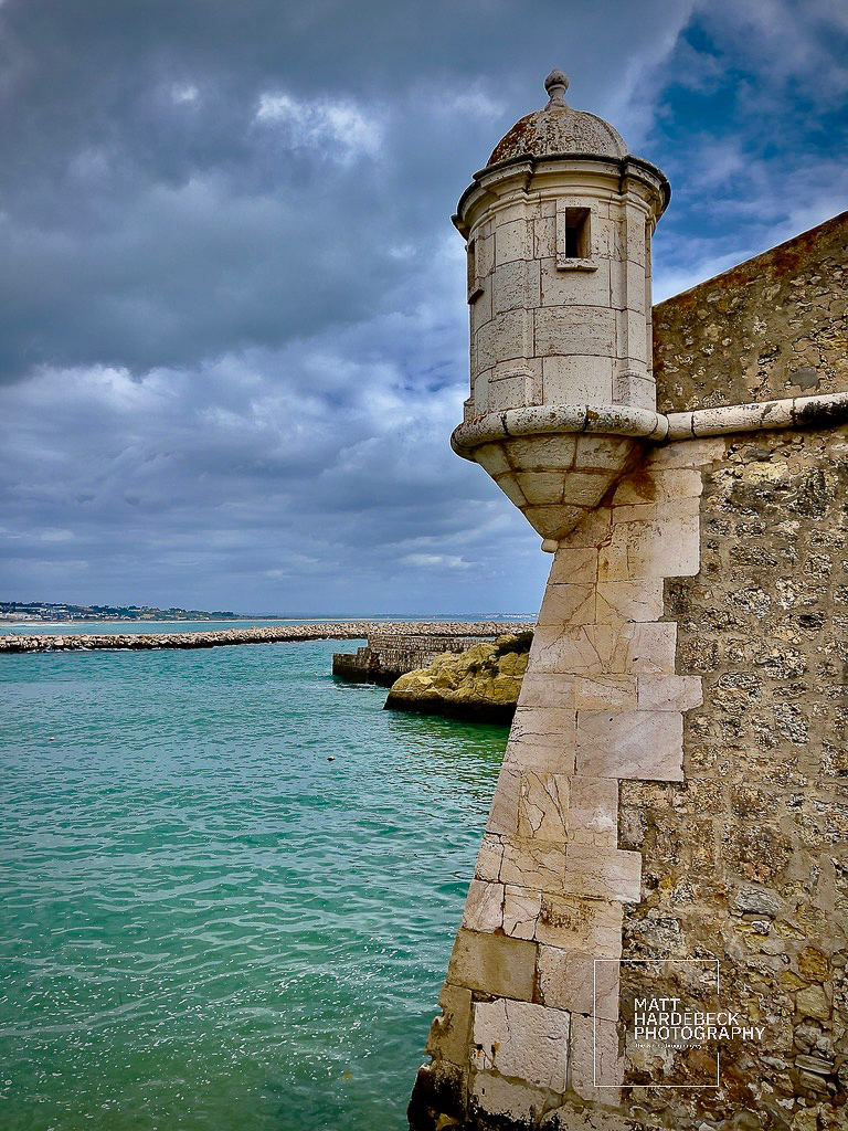 Watchtower on the seaward wall of the Forte da Ponta da Bandeira, overlooking turquoise water.
