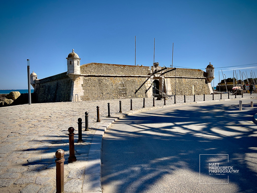 Entrance to the Forte da Ponta da Bandeira under a clear blue sky.