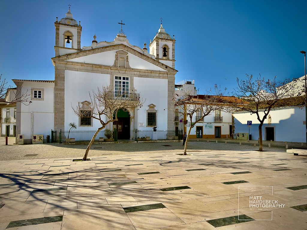 Baroque-style church with twin bell towers and open square in Lagos, Portugal.