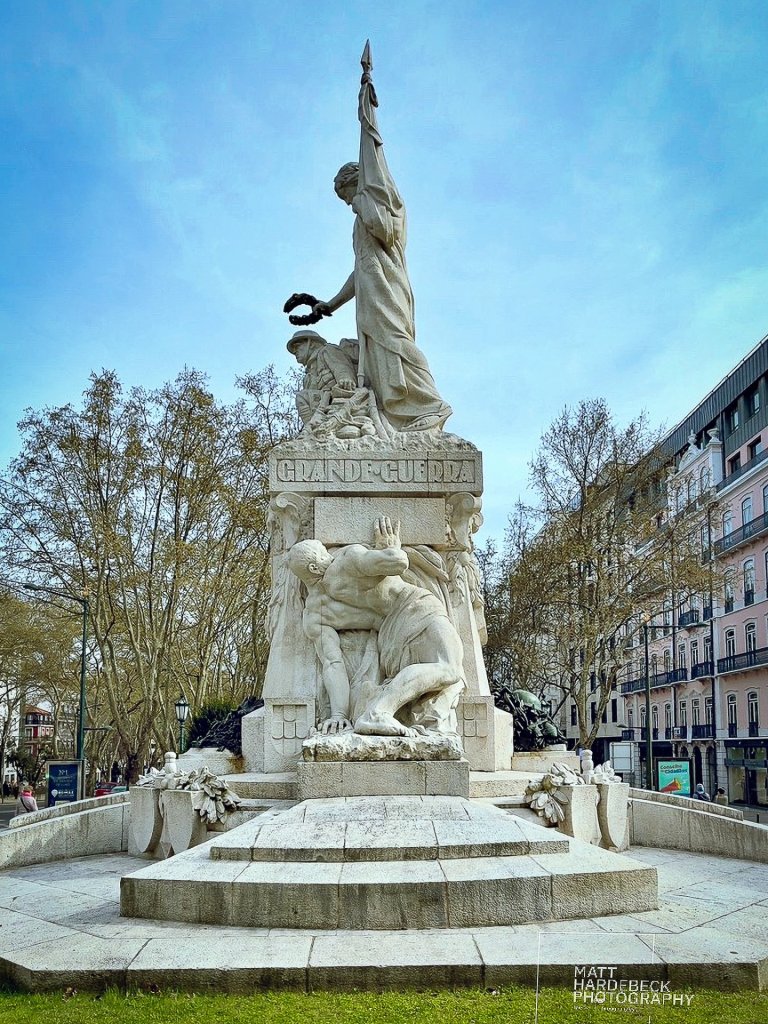 White stone monument in Lisbon honoring soldiers of the Great War, with sculpted figures of heroism and sacrifice.