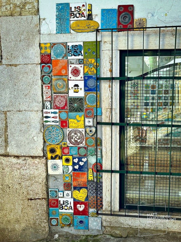 Colorful azulejo tiles arranged decoratively on a Lisbon street wall.