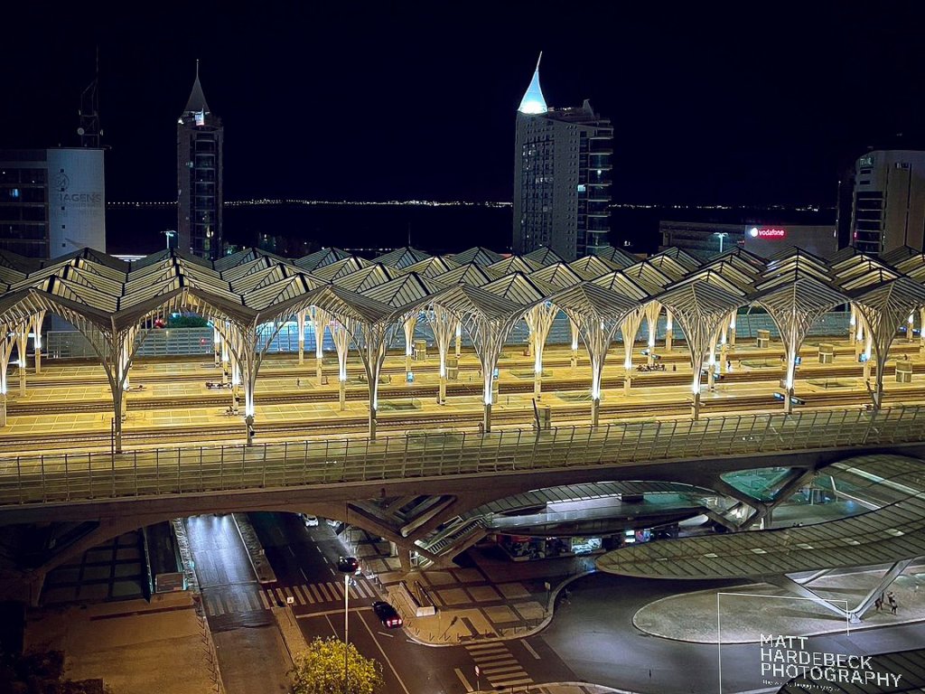 Nighttime view of the modern Gare do Oriente train station in Lisbon, designed by Santiago Calatrava, with its illuminated steel and glass canopy.