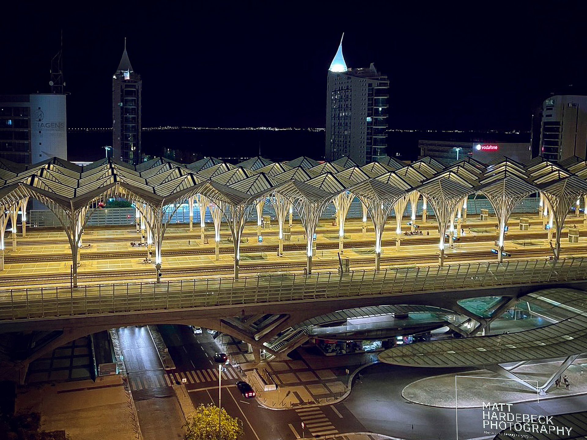 Nighttime view of the modern Gare do Oriente train station in Lisbon, designed by Santiago Calatrava, with its illuminated steel and glass canopy.