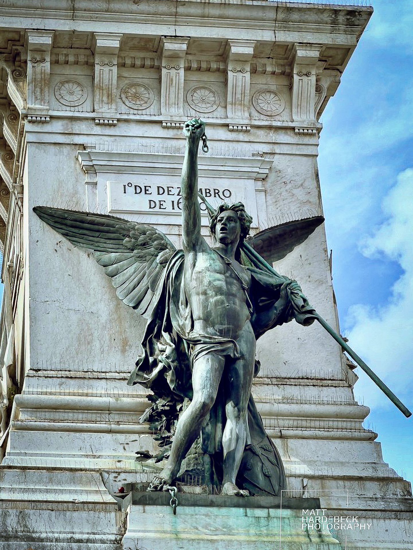 Bronze winged figure holding broken chains, part of Lisbon’s Monument to the Restorers commemorating the restoration of independence in 1640.