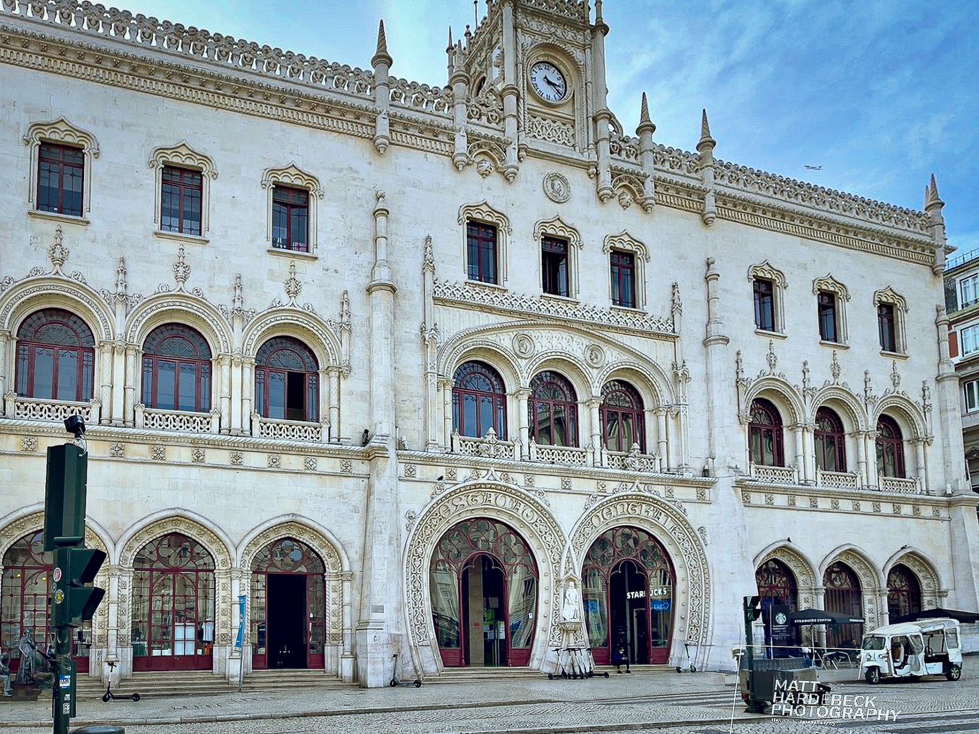 The Neo-Manueline façade of Lisbon’s Rossio Railway Station with its ornate arches and clock tower.