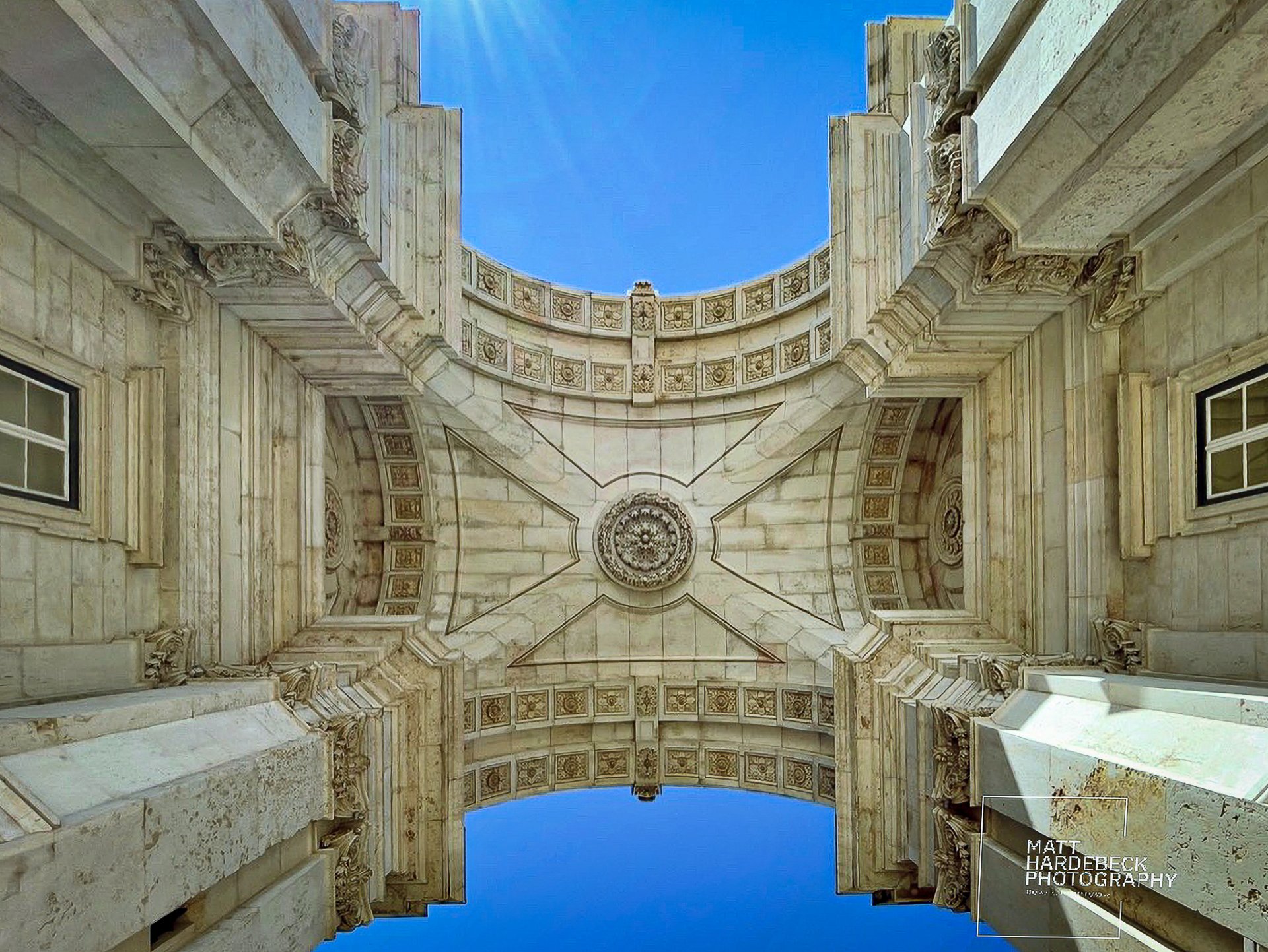 Upward view of the intricate stonework and carvings on the Arco da Rua Augusta in Lisbon, Portugal.
