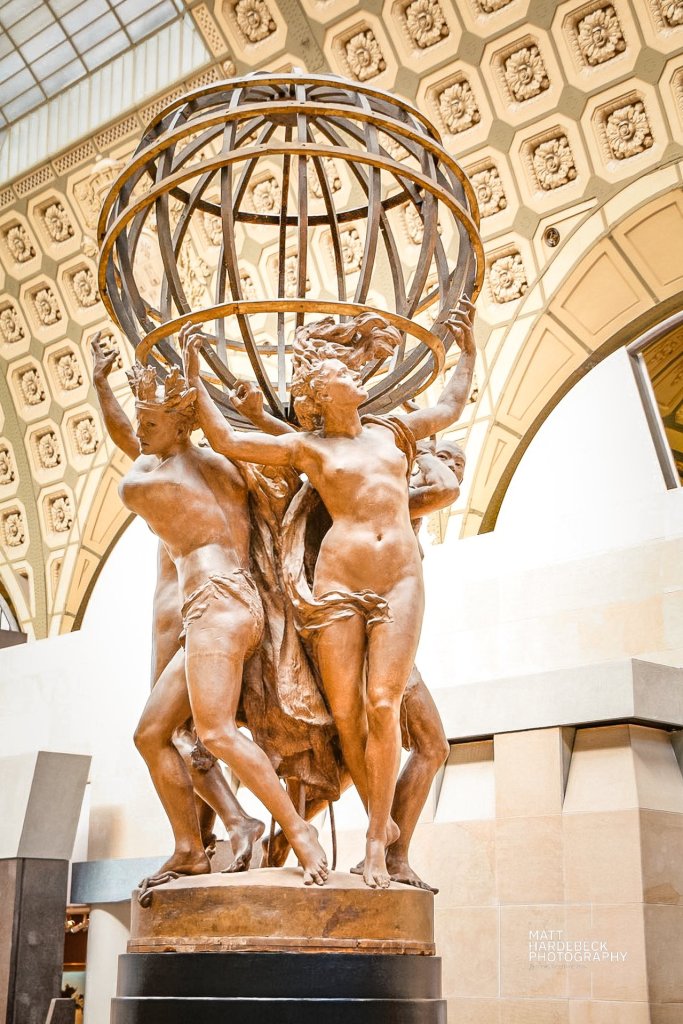 Bronze sculpture of four allegorical nude figures supporting an armillary sphere at the Musée d'Orsay in Paris.
