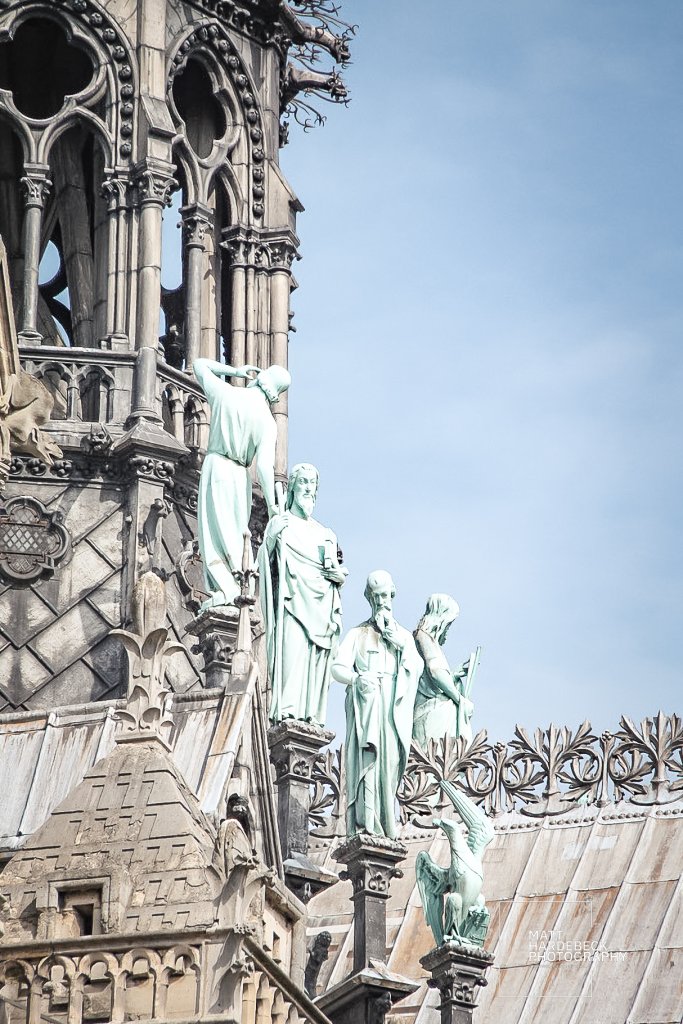 Copper statues of apostles on the roof of Notre-Dame Cathedral, surrounding the base of the spire.