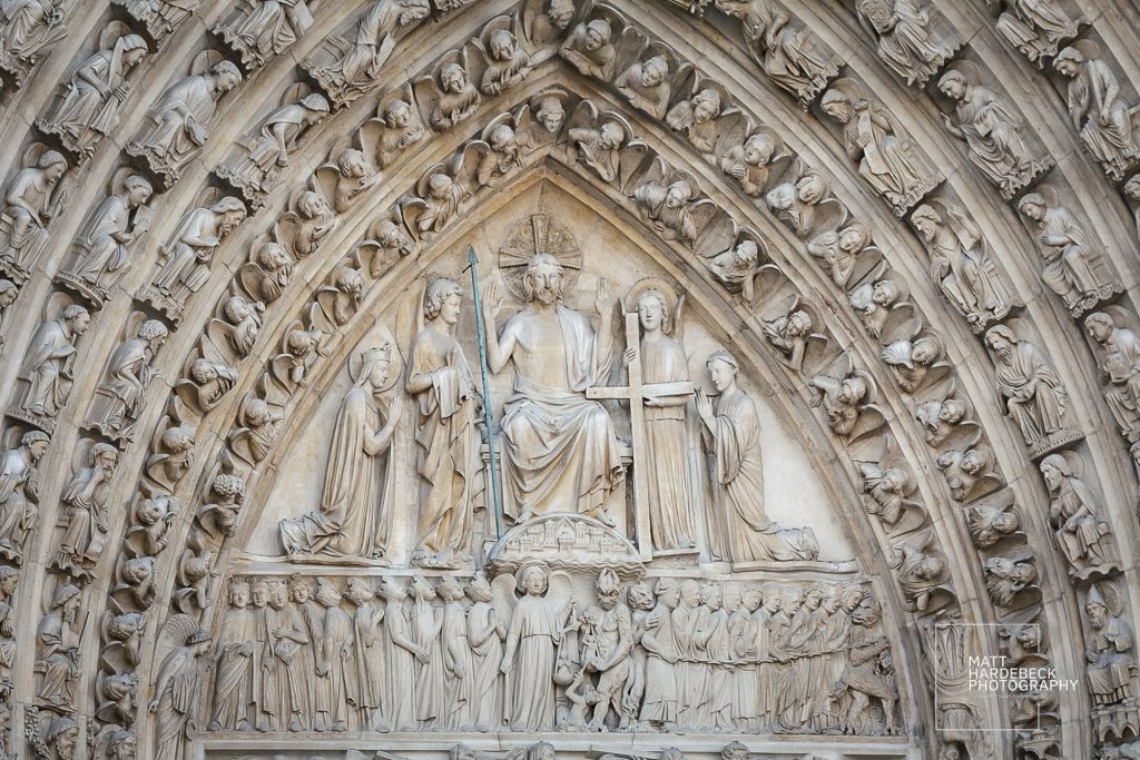 Detailed tympanum of the central portal at Notre-Dame Cathedral, depicting the Last Judgment with Christ, angels, saints, and souls.