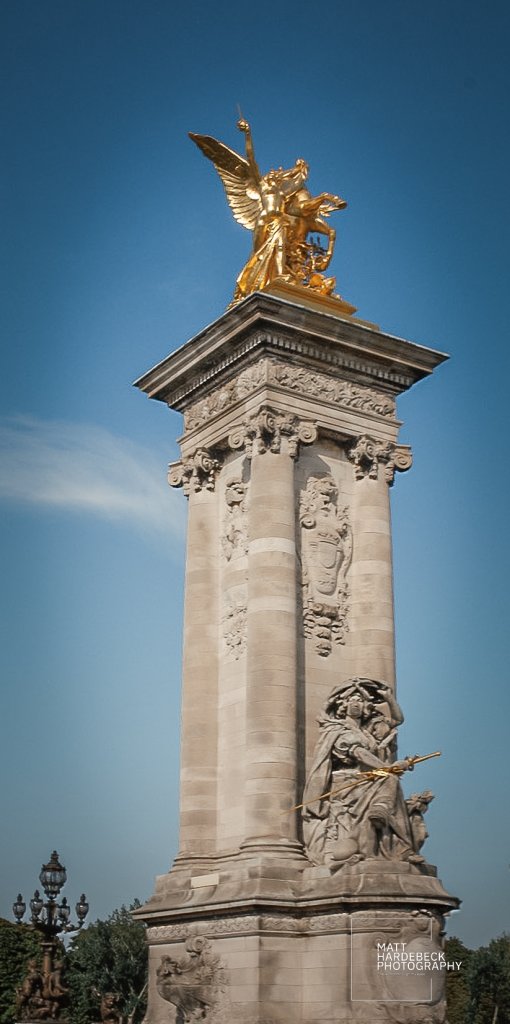 Golden statue of winged horse and rider atop one of the pillars of Pont Alexandre III in Paris