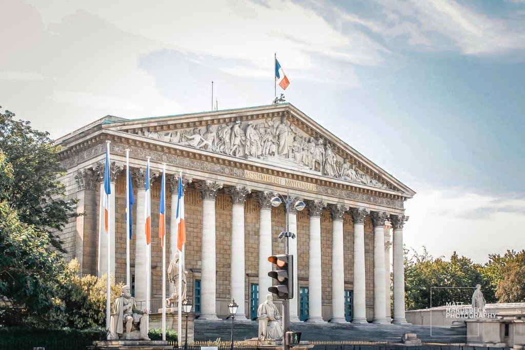 The Assemblée Nationale building with French flags and neoclassical columns