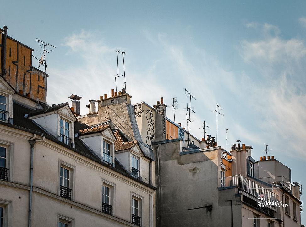 Rooftops of Paris apartments with graffiti and TV antennas