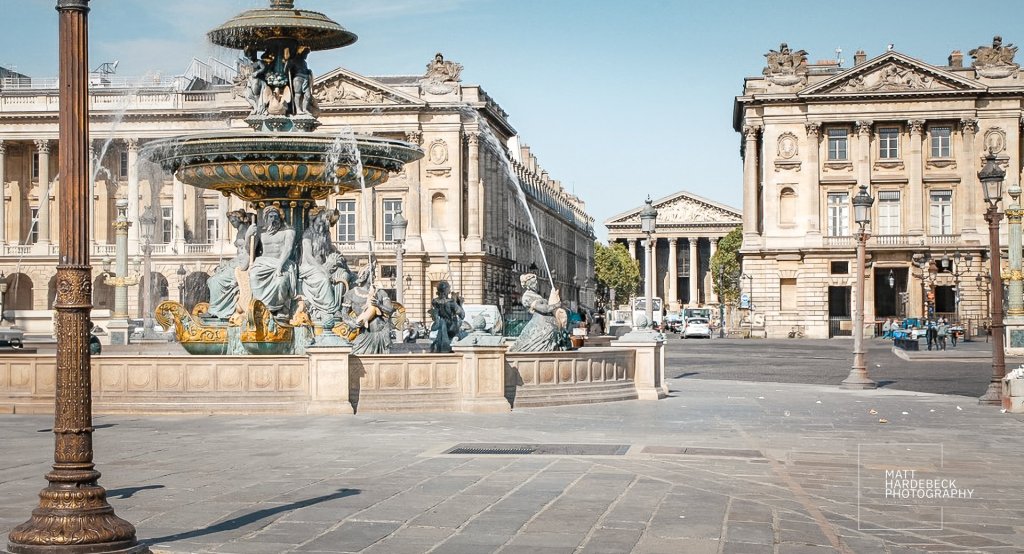 View of the Fontaine des Mers in Place de la Concorde with neoclassical buildings in the background.
