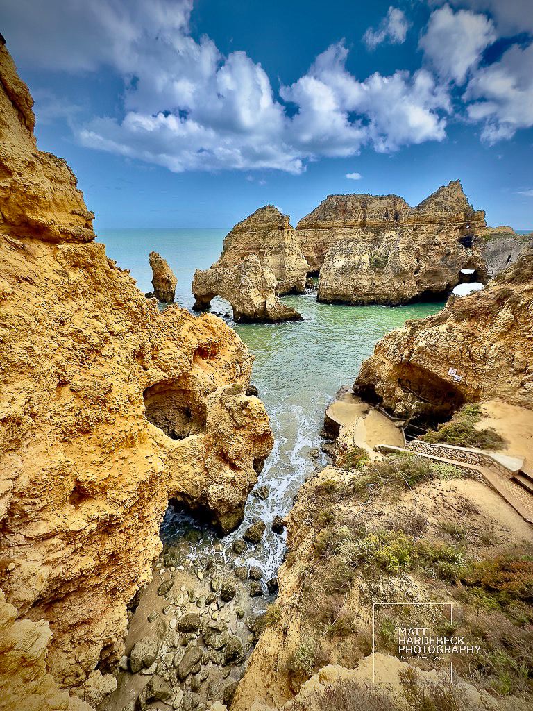 View from above of jagged limestone formations at Ponta da Piedade with steps leading to the water.