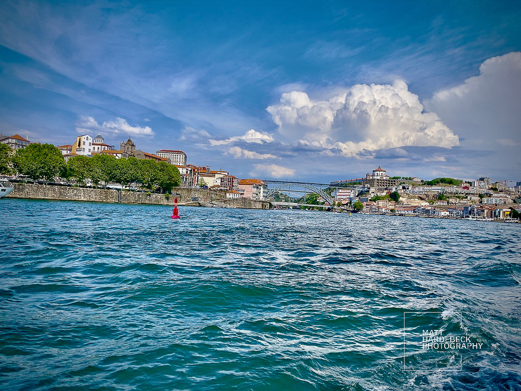 Waterfront view of Porto with the Dom Luís I Bridge and city skyline.