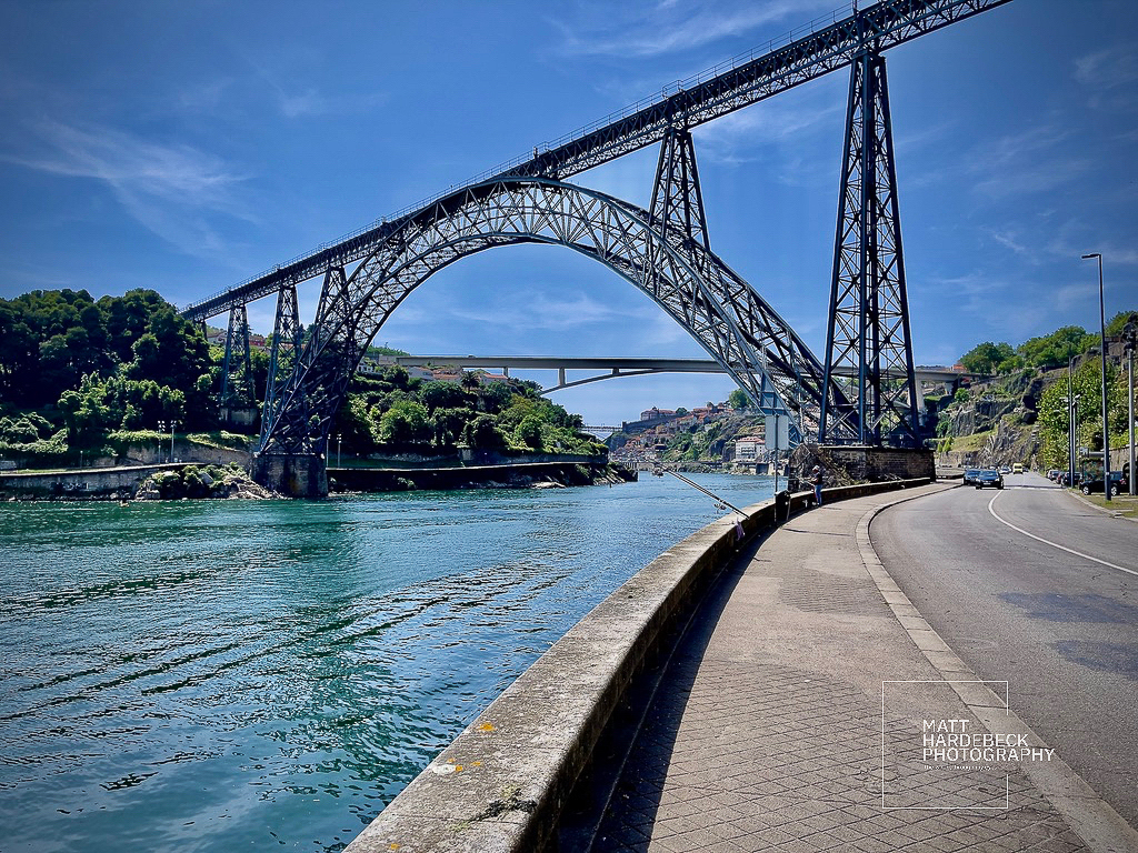 he arched metal Ponte de São João spanning the Douro River under a clear blue sky.
