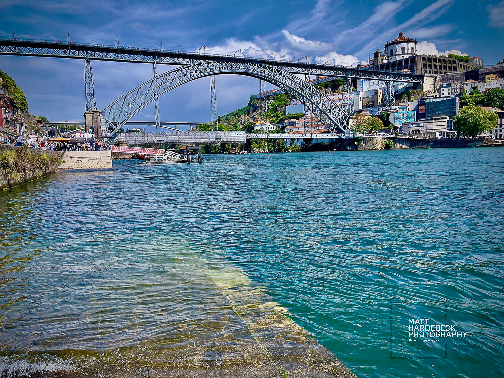 iew of the Dom Luís I Bridge spanning the Douro River in Porto, Portugal, with the Serra do Pilar Monastery in the background.