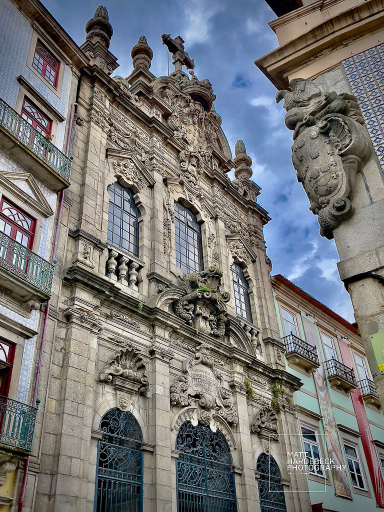 Baroque facade of the Igreja da Misericórdia in Porto, Portugal, featuring elaborate stone carvings and arched windows.