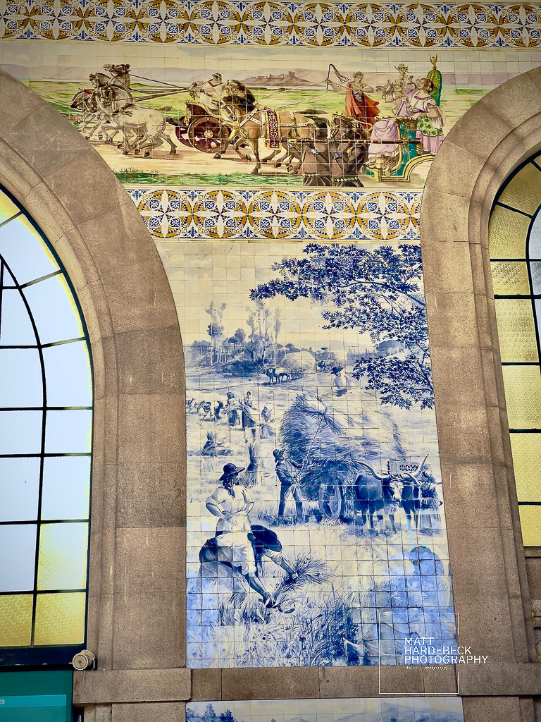 Colorful azulejo tile mural depicting agricultural scenes inside São Bento Railway Station.