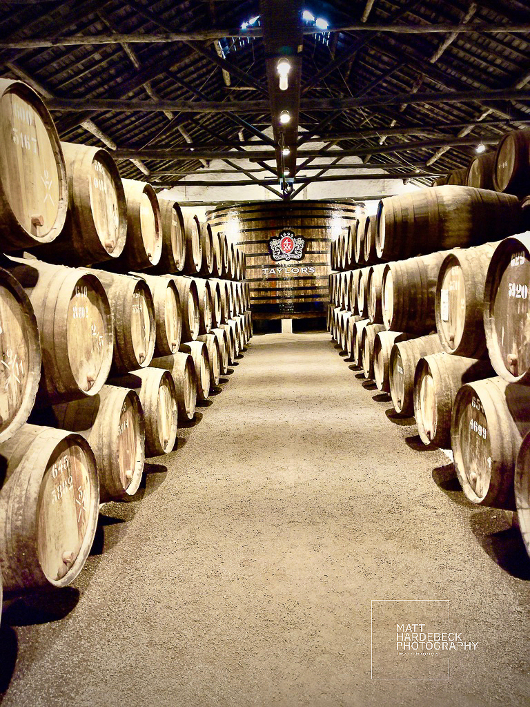 Rows of wooden port wine barrels inside Taylor’s wine cellars in Porto.