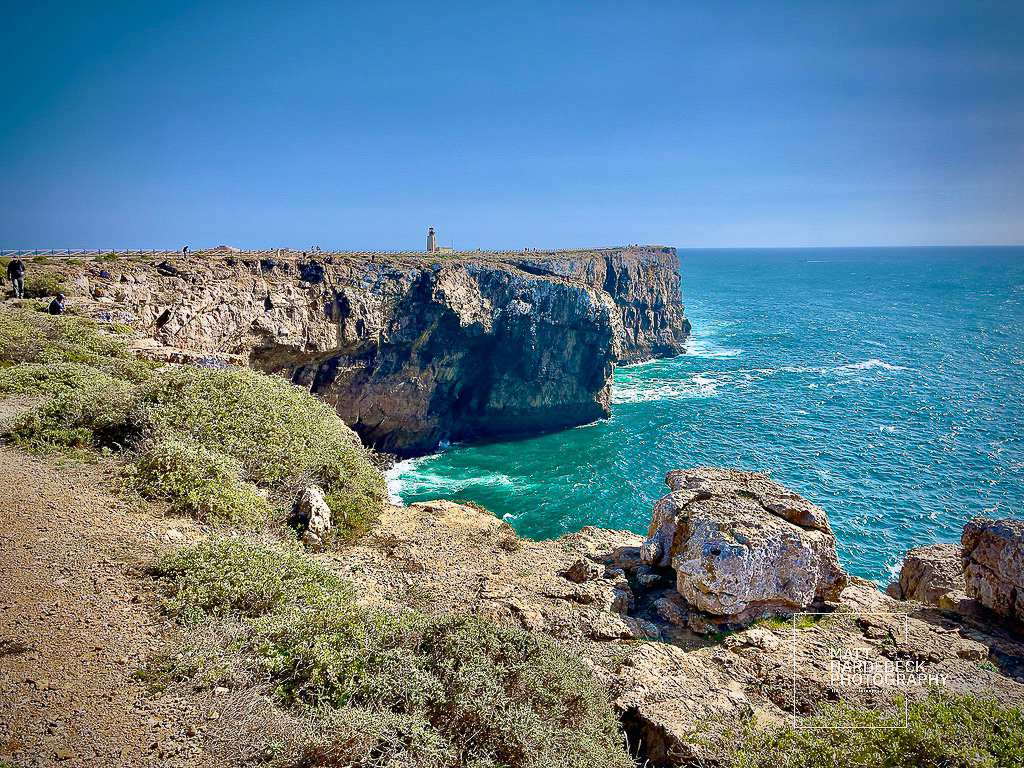 View of Cabo de São Vicente lighthouse perched on cliffs above the Atlantic Ocean in Sagres, Portugal.