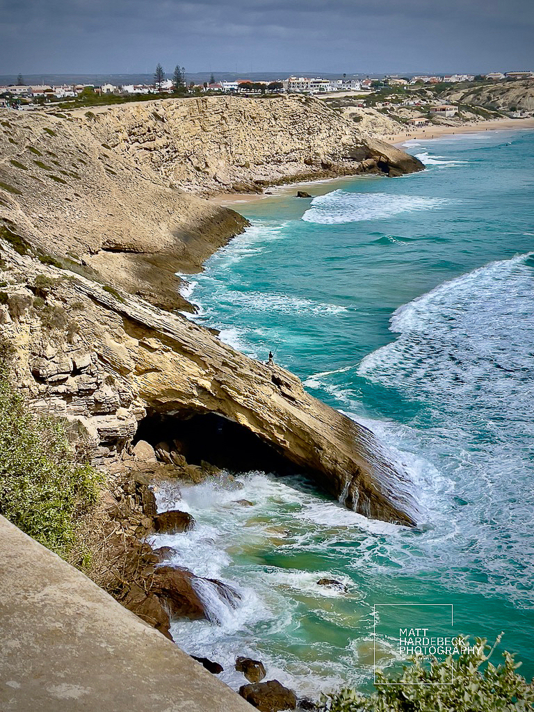 Rock arch formation along the Algarve coast with waves crashing beneath near Sagres, Portugal.