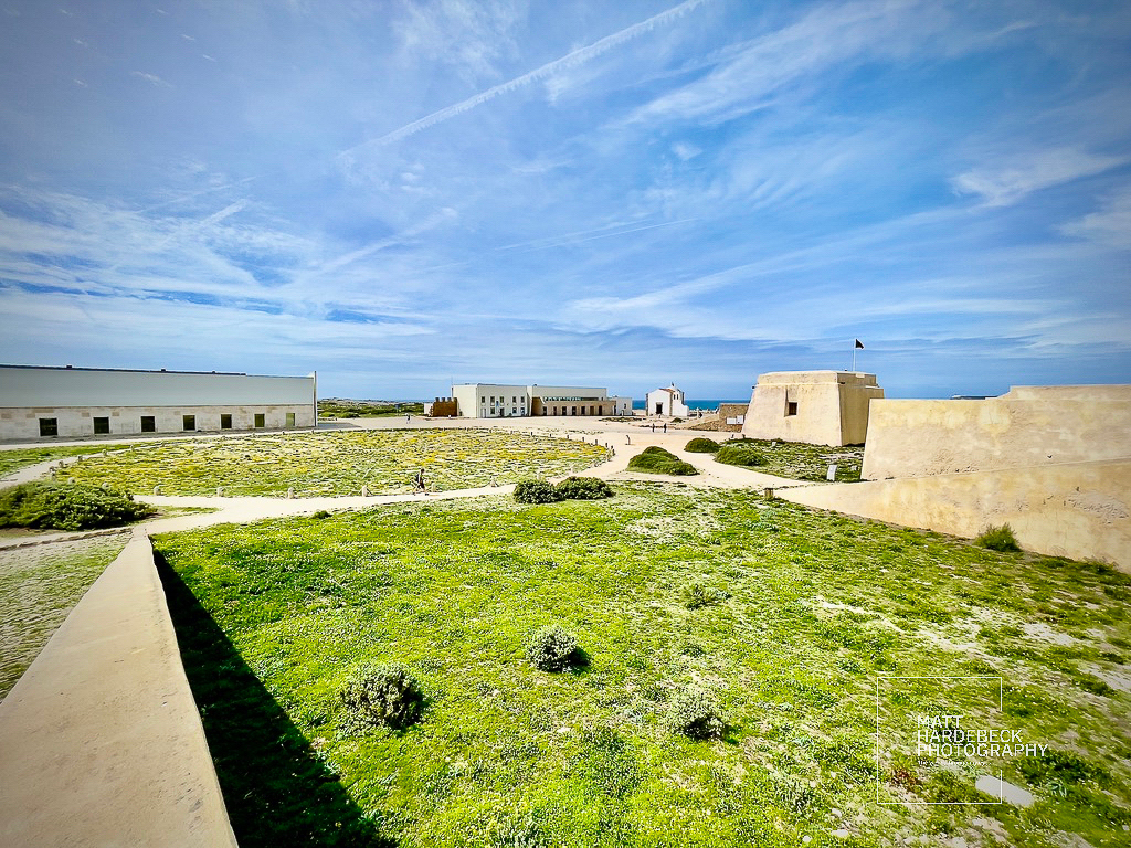 Open courtyard and fort walls of Fortaleza de Sagres with the chapel in the distance, Portugal.
