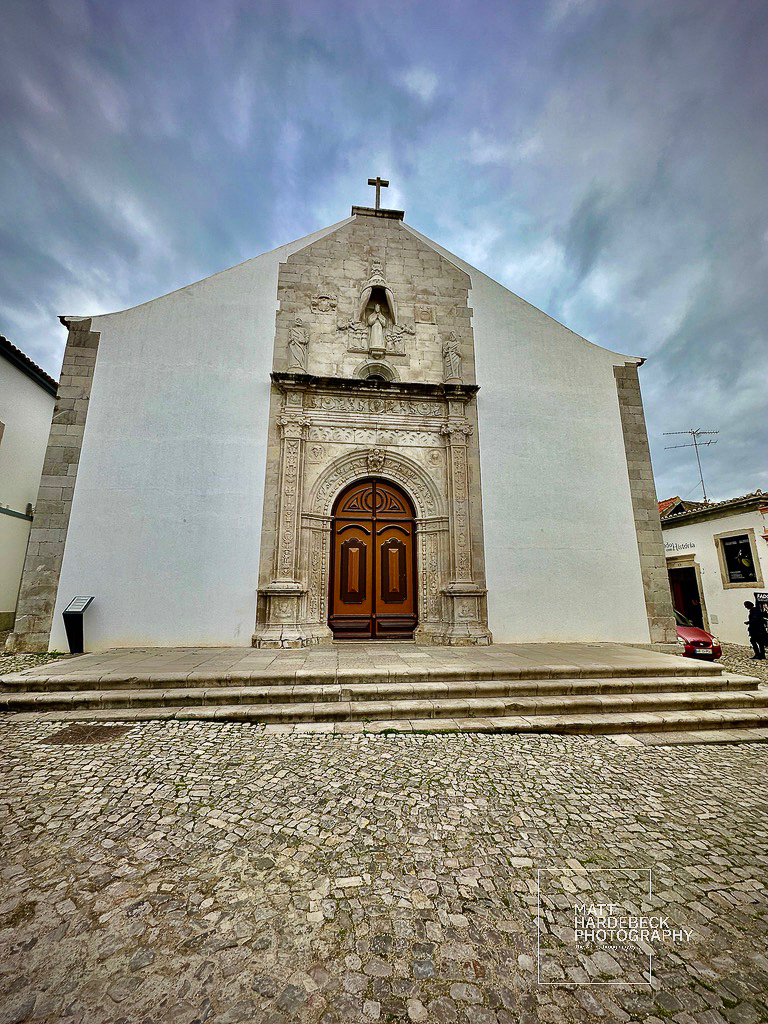Stone façade church with intricate Manueline doorway in Tavira, Portugal.