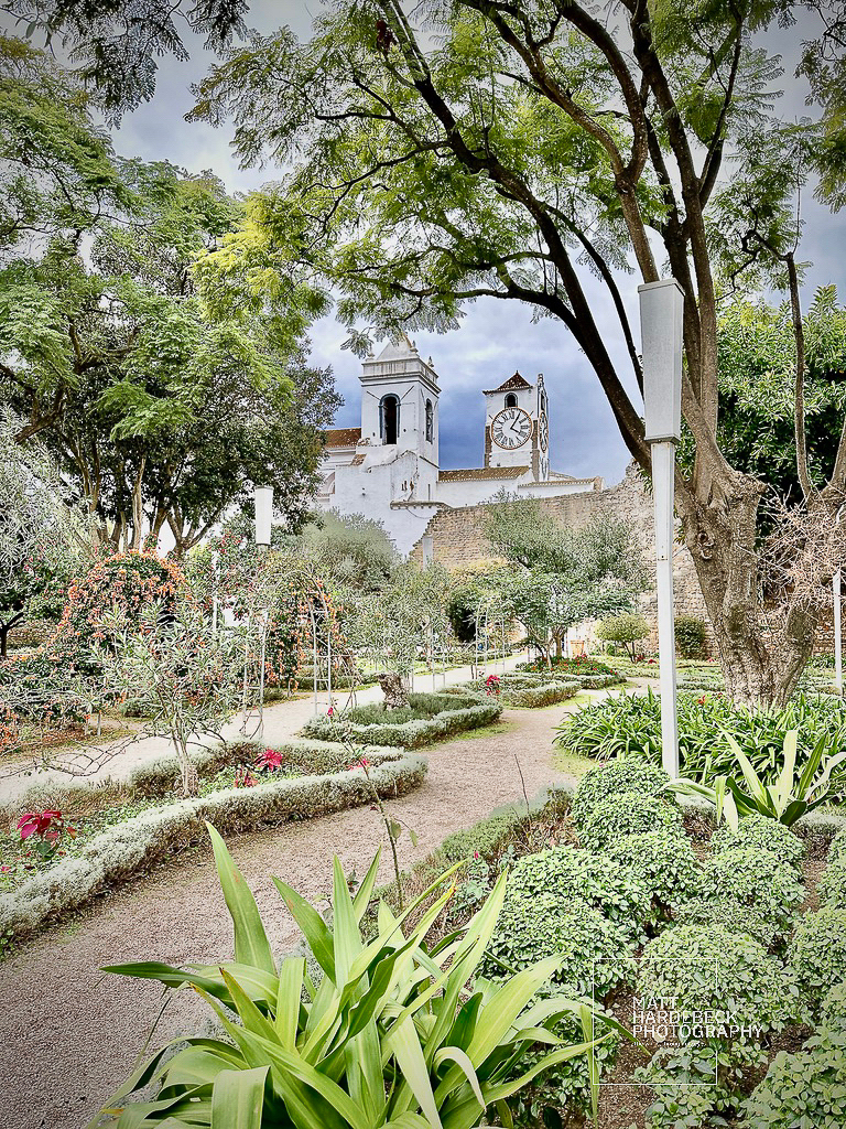 Lush garden paths with view of Tavira’s church towers and clock.