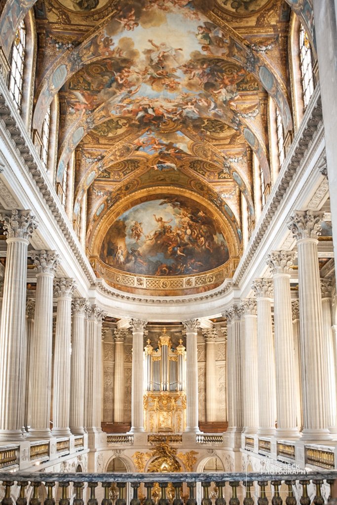Baroque ceiling and organ of the Royal Chapel at Versailles with golden detailing and dramatic painted frescoes.